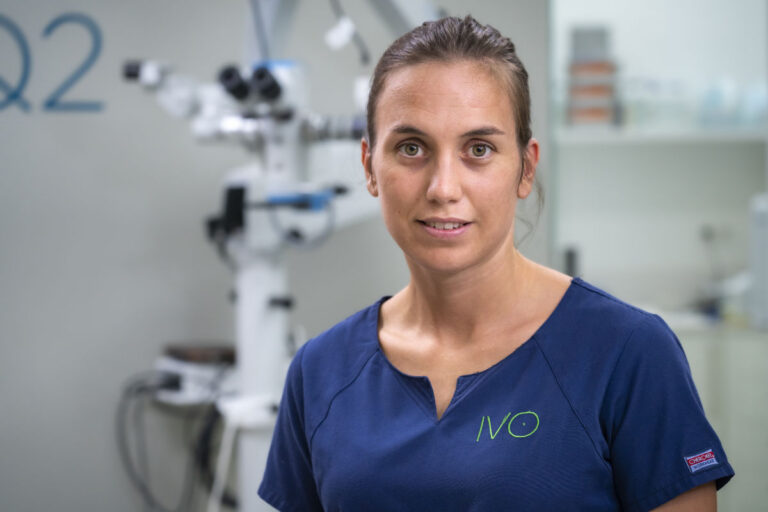 Retrato de la Dra. María Simó, veterinaria oftalmóloga, con uniforme clínico azul en la zona quirúrgica de IVO.
